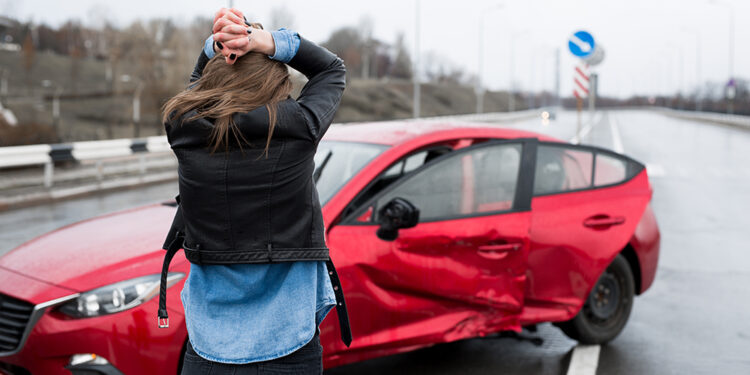Woman stands near a broken car after an accident. call for help. car insurance נסיעה בטוחה!